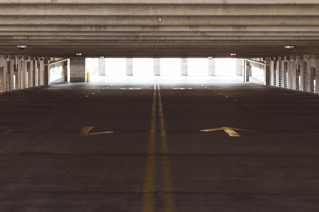 Estacionamiento y calle marr&oacute;n, lotes de estacionamiento amplios y concurridos.