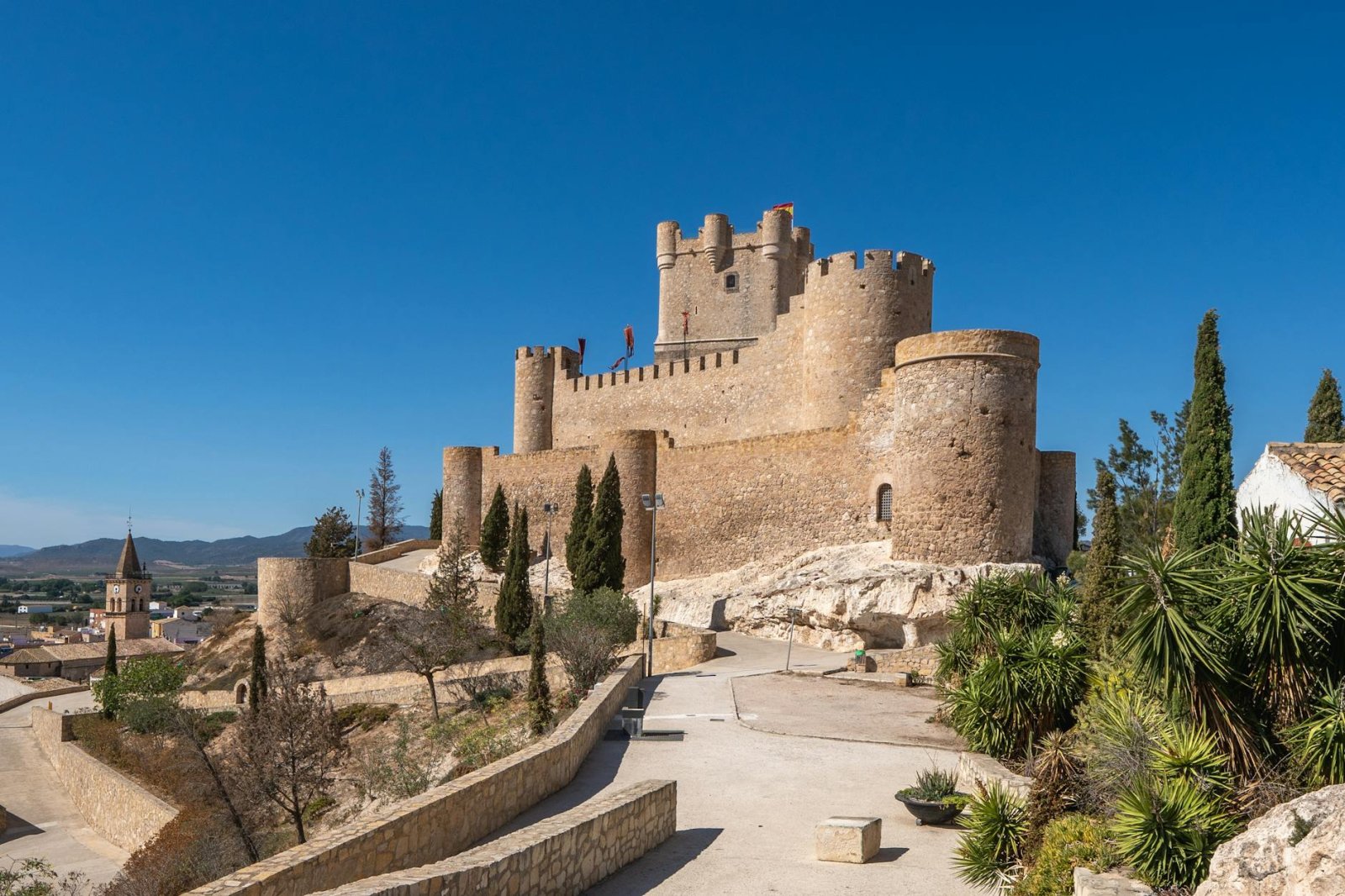 Castillo de Atalaya en Villena, España, bajo cielo azul, arquitectura medieval.