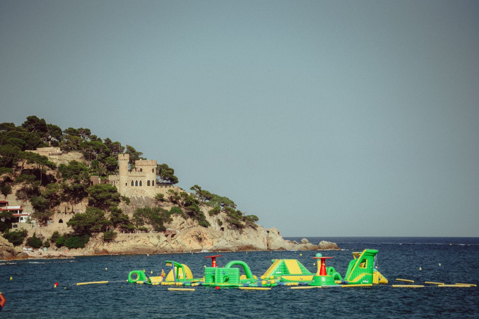 Castillo hist&oacute;rico en colina rocosa y parque acu&aacute;tico inflable en Lloret de Mar, Espa&ntilde;a.