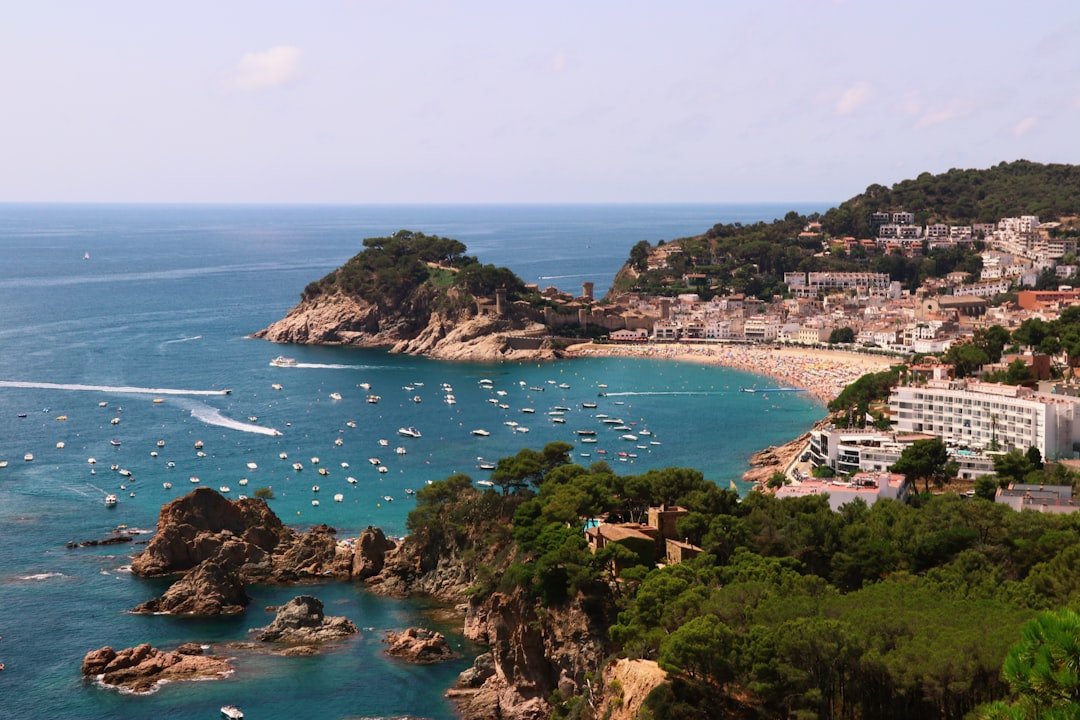 Vista panorámica de la playa de Lloret con embarcaciones, ilustrando empresas de embarcadero y cómo elegirlas.