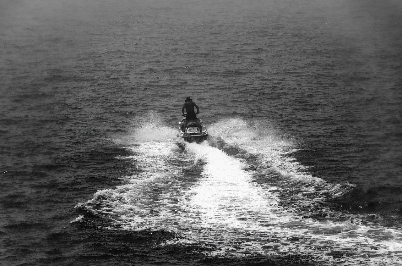 Jet ski negro y blanco surcando el mar a gran velocidad, naturaleza y motor en acción.
